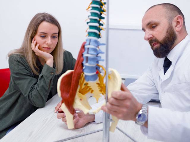 medico ortopedico spiega a paziente la causa del dolore al fianco